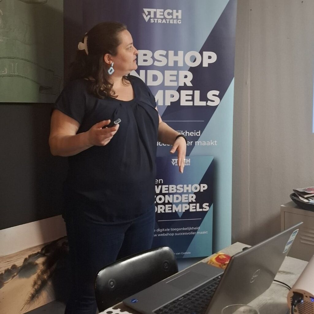 Elvira staat voor haar laptop uit te leggen tijdens een workshop.